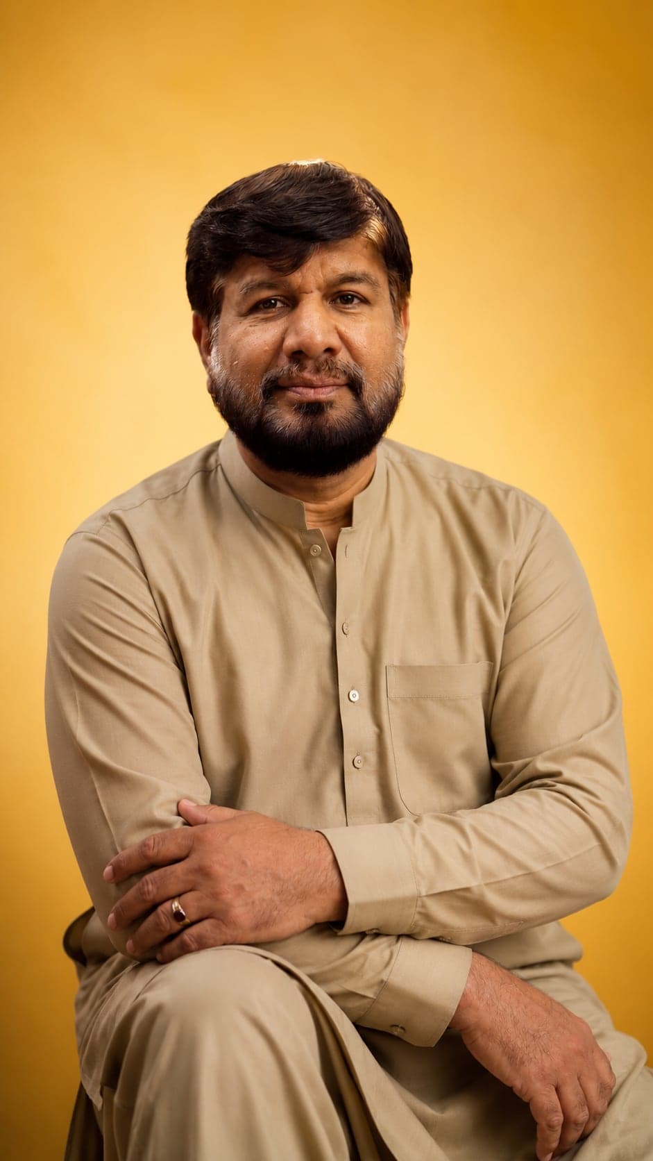 Shaukat Habib, founder of Hot n Roll, portrait against a gold backdrop